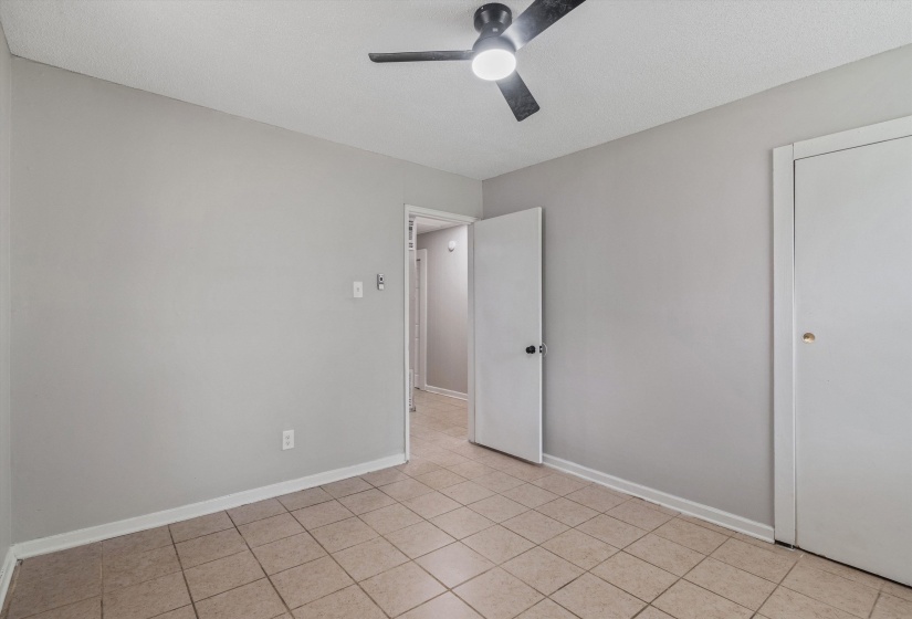 Square tile flooring, light gray wall paint, and white trim