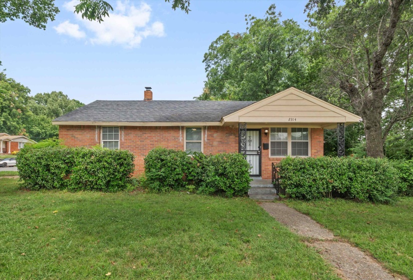 Brick facade home featuring a covered front porch with decorative iron columns