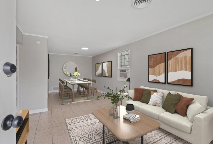 Spacious living area featuring light-toned walls, tile flooring, window with security bars, and a ceiling-mounted ventilation system