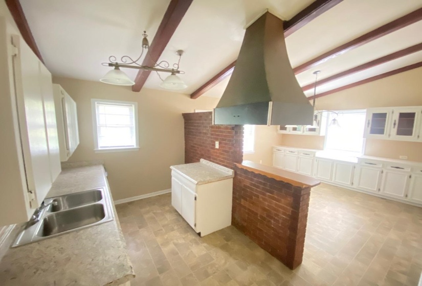 Vaulted ceiling featuring exposed wood beams