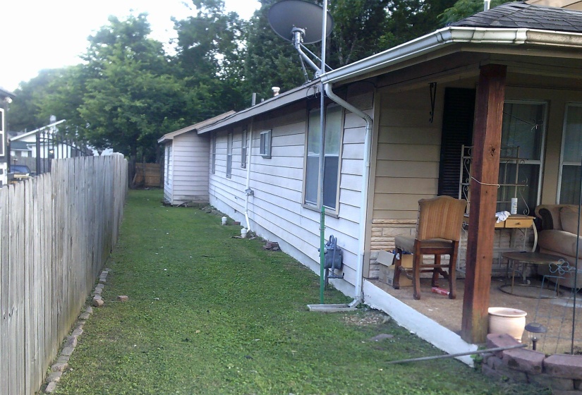 Exterior siding with a covered porch featuring a wood support beam