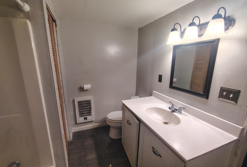 Bathroom featuring a white vanity with integrated sink, chrome faucet, and a wall-mounted mirror with a black frame