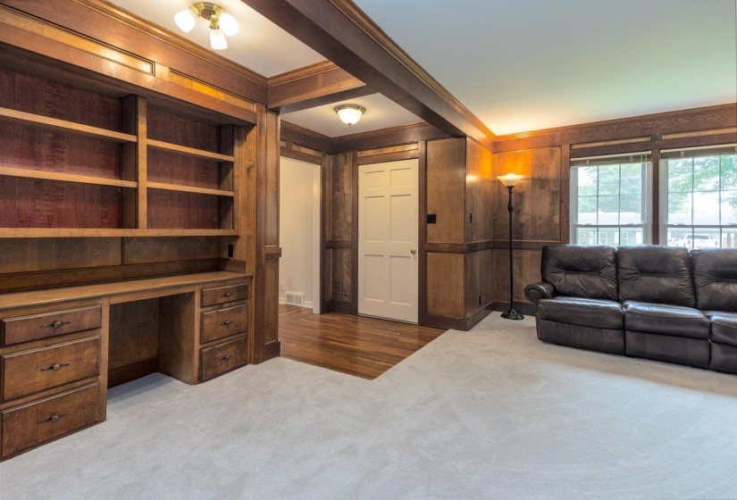 Built-in wood cabinetry with integrated desk and shelving, complemented by wood paneling and trim