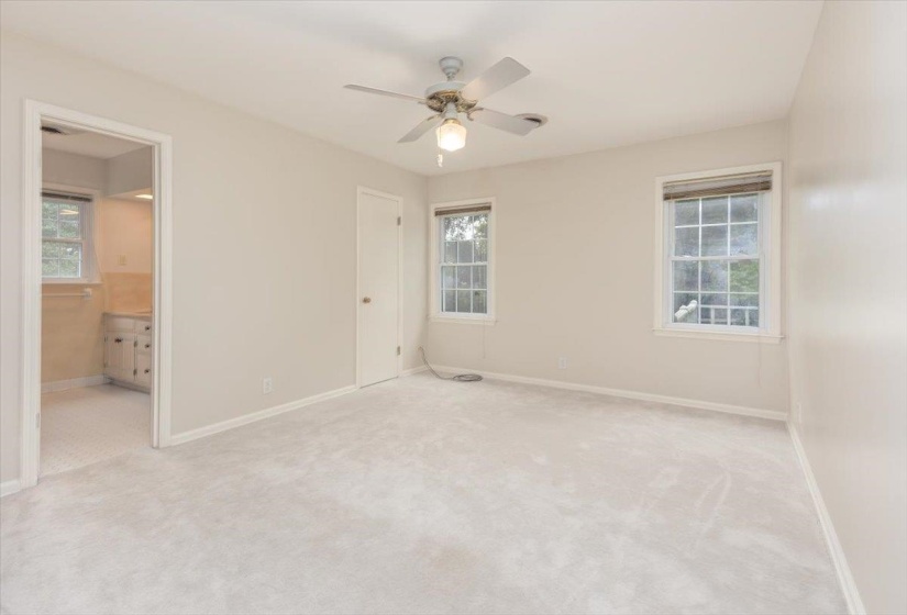 Carpeted room with neutral wall tones and a ceiling fan with integrated lighting