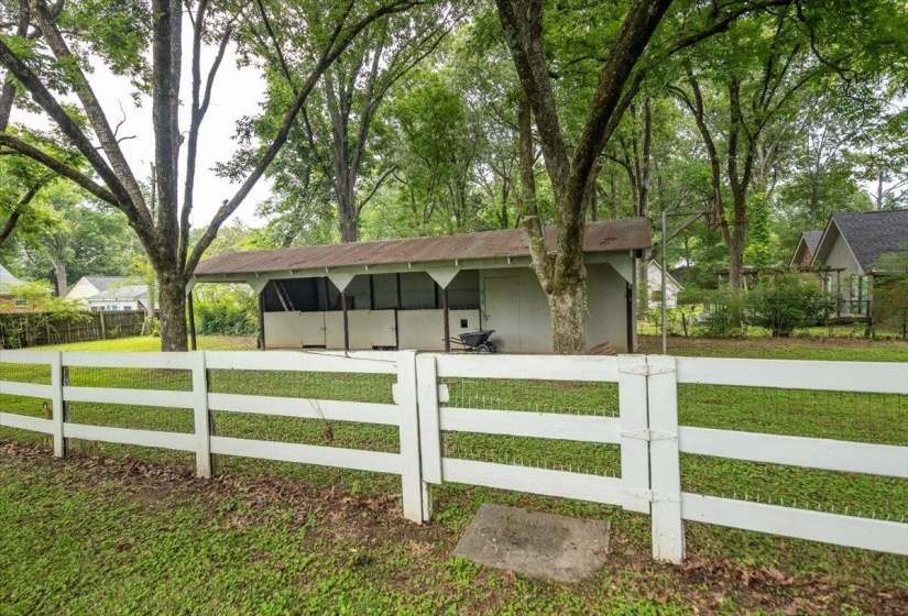 White four-rail fence enclosing a grassy area