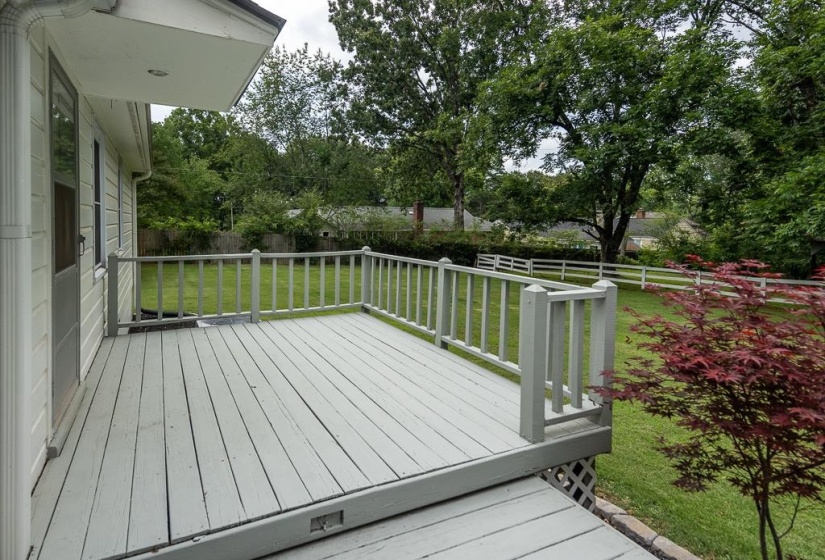 Expansive outdoor deck with a painted wood surface and white railing