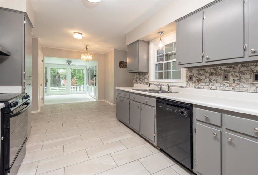 Kitchen featuring light gray cabinetry, white countertops, a mosaic tile backsplash, stainless steel double basin sink, and wood-finish flooring
