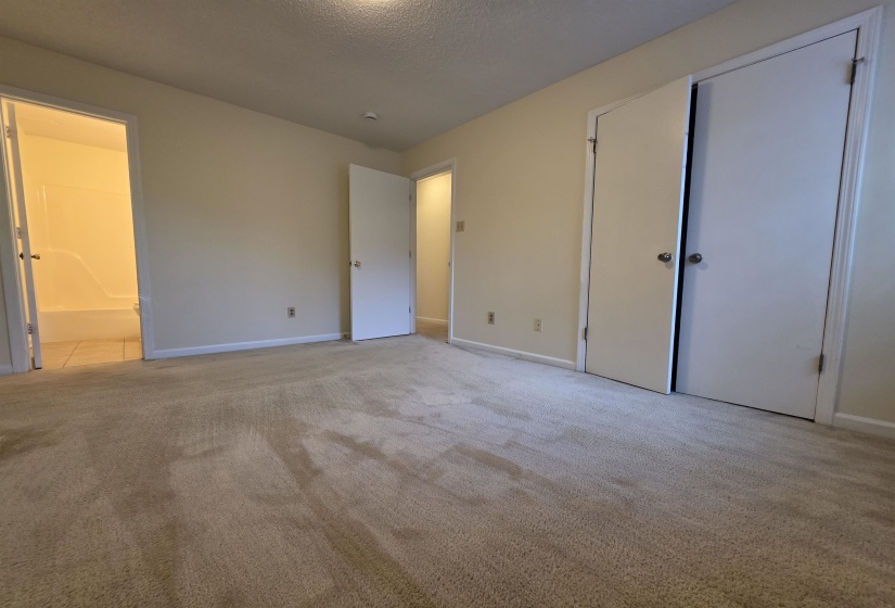 Carpeted room featuring light-colored walls, white trim, and white doors