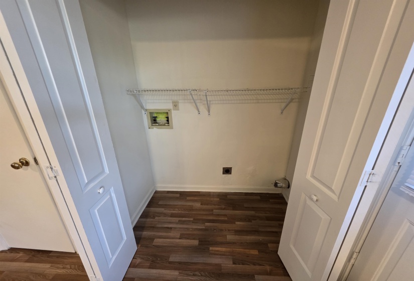 Dedicated utility closet featuring wood-finish flooring