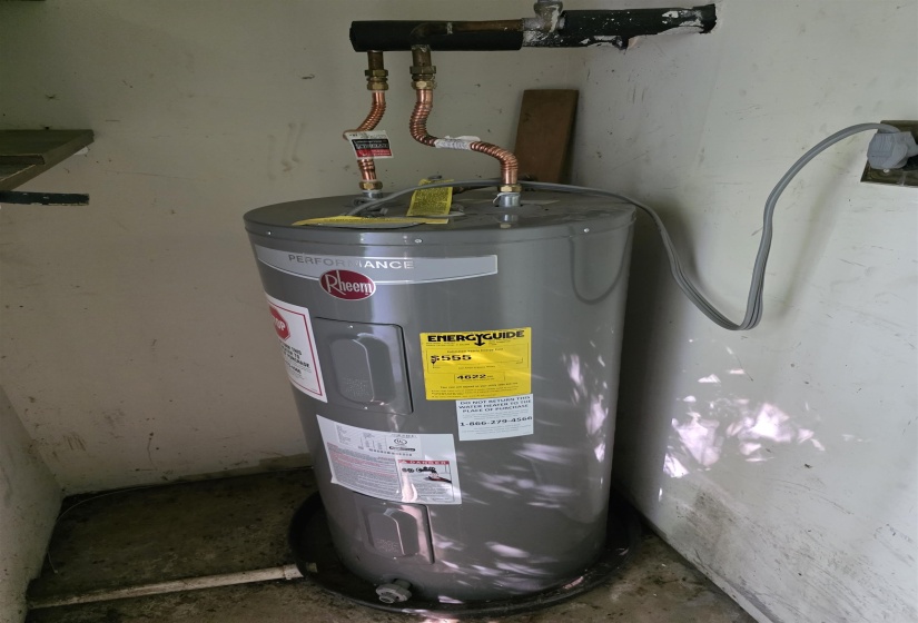 Water heater installation featuring a Rheem Performance unit, copper piping, and an energy guide label