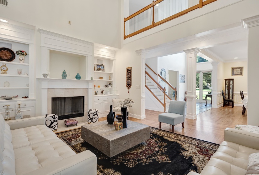Great room featuring a fireplace with a stone surround, flanked by built-in shelving and cabinetry