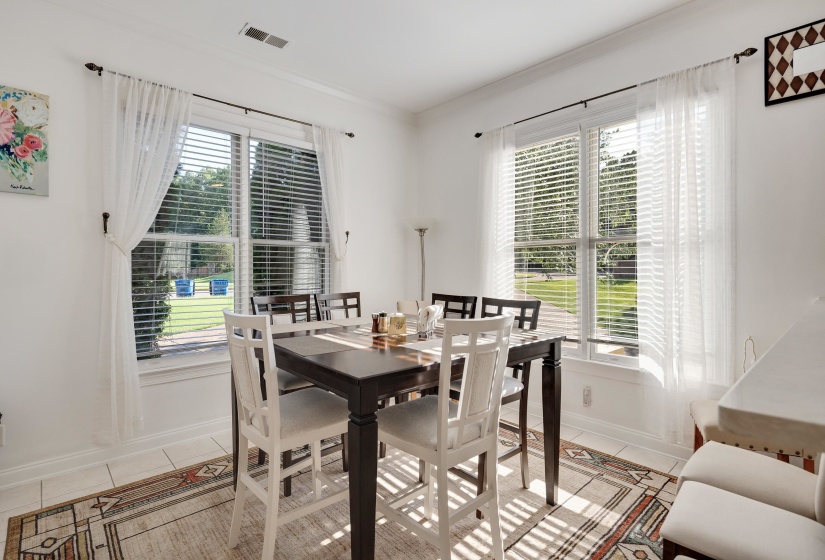 Bright interior space featuring multiple windows with blinds, white trim, and crown molding