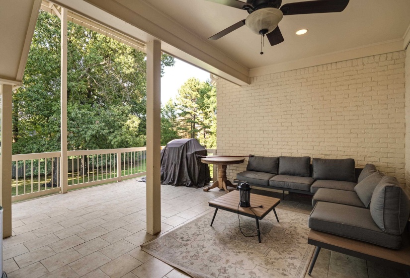 Covered outdoor patio featuring light-toned brick wall, recessed lighting, and a ceiling fan