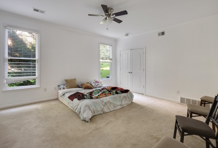 Spacious room featuring neutral carpeting, white walls, and crown molding