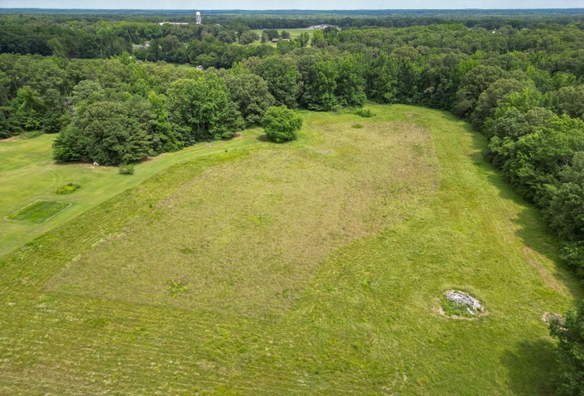 A breathtaking aerial view showcasing the full 8.67 acres surrounded by mature trees and rolling countryside. The perfect setting for a custom estate, private retreat, or dream home.