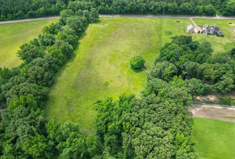 A stunning overhead perspective showcasing the property's unique layout, usable acreage, and beautiful natural surroundings.