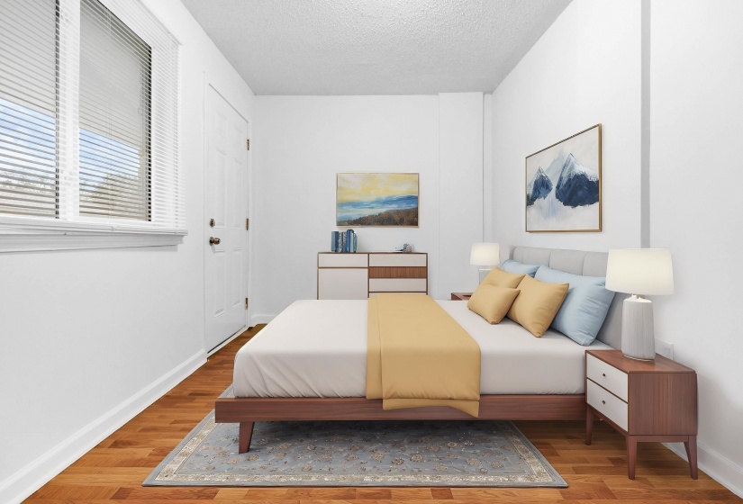 Bright room featuring wood-finish flooring, white walls, and a window with blinds