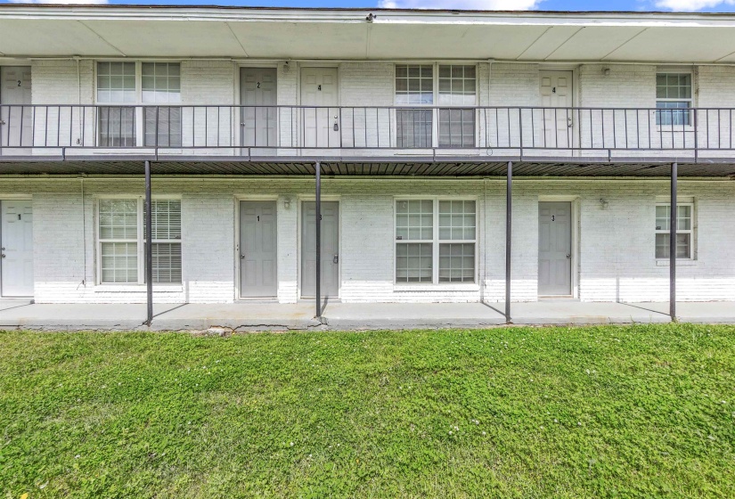 White brick exterior featuring multiple units across two levels