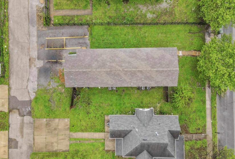 Expansive property featuring two distinct structures, a lengthy asphalt driveway, and a concrete paver walkway