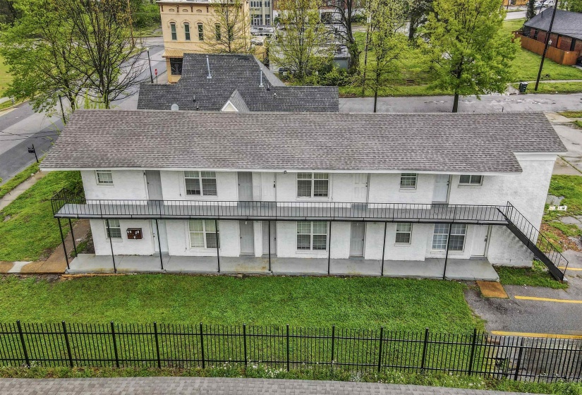 Two-story multi-unit property with a shingle roof and white stucco exterior