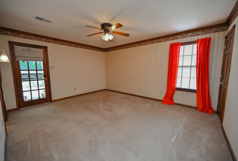 Primary bedroom with attached private bath.  Door leads to covered back patio. Bedroom also has spacious walk-in closet.