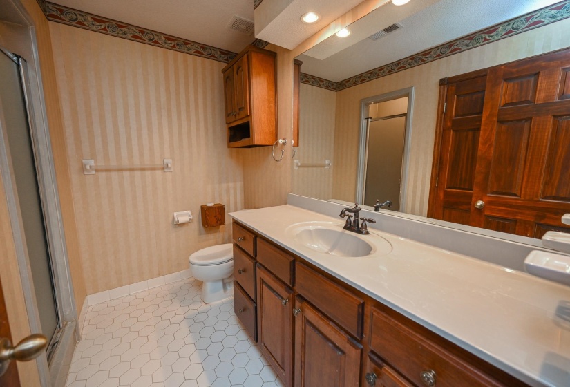Primary bath with large vanity, linen closet and shower.