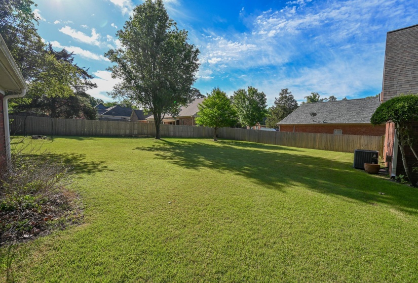 Beautiful backyard with wooden fence and established landscaping.