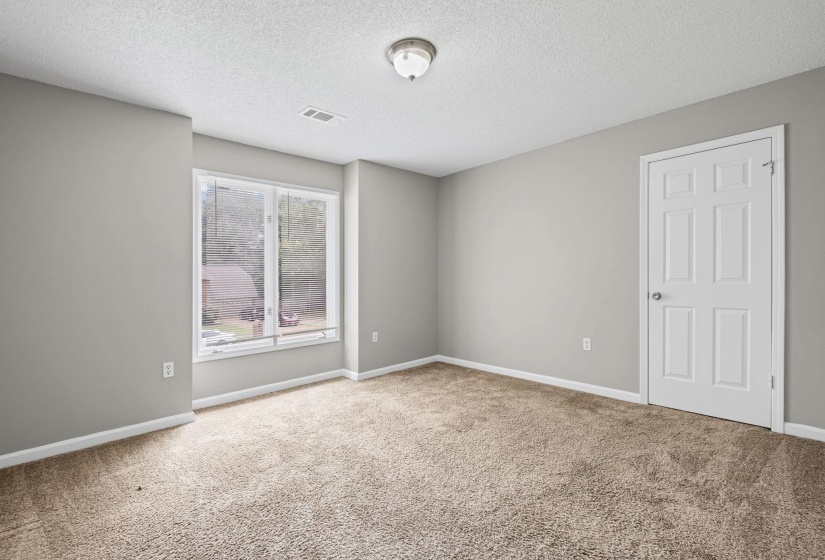 Carpeted room featuring light gray walls, white trim, and a multi-pane window