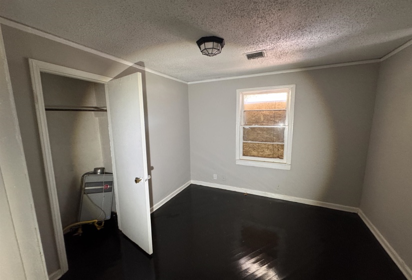 Room featuring painted walls, dark wood-finish flooring, and crown molding