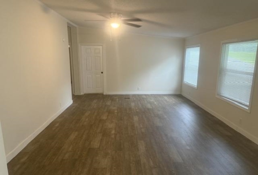 Spacious interior featuring wood-finish flooring, neutral paint, and white trim