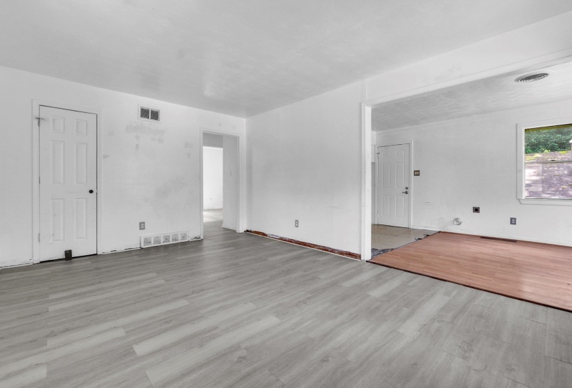 Open-concept living space featuring light wood-finish flooring and white painted walls