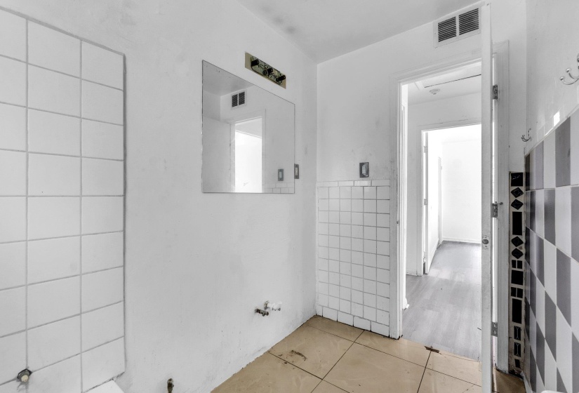 Bathroom space featuring partial white wall tiling and checkerboard wall tiling