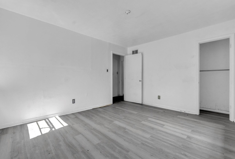 Light wood-finish flooring with white walls and baseboards