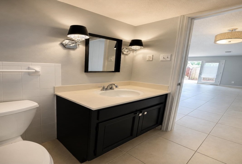 Bathroom vanity with a light-colored countertop, undermount sink, and chrome faucet