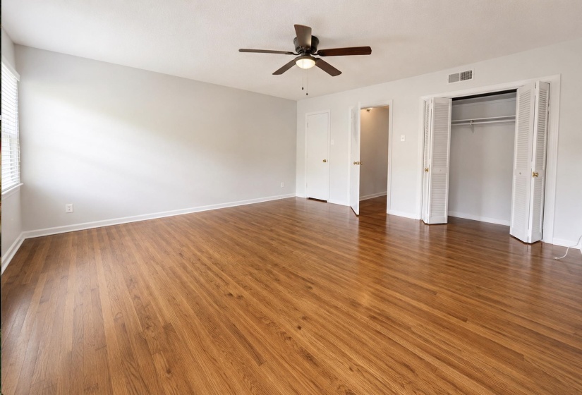 Spacious room featuring wood-finish flooring and a neutral color palette