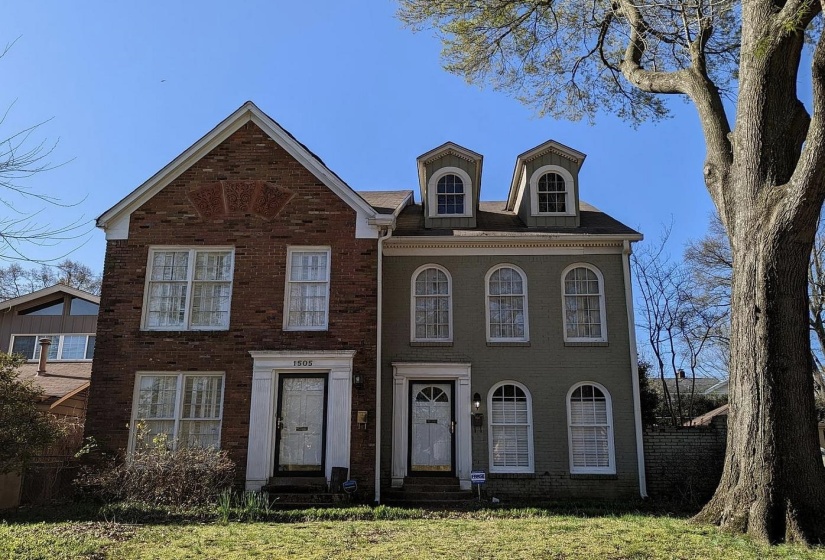 Traditional brick townhome with a prominent gabled roofline and decorative brickwork
