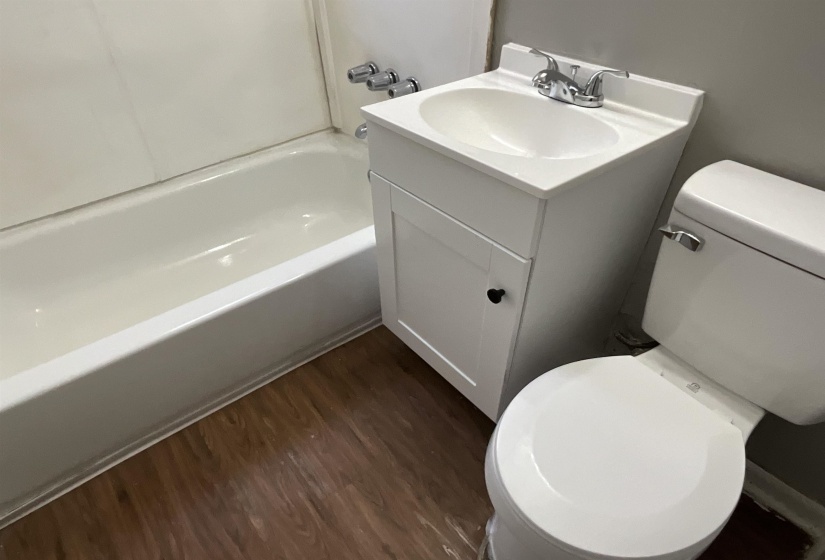 Bathroom with  shower combination, vanity, toilet, and wood finished floors