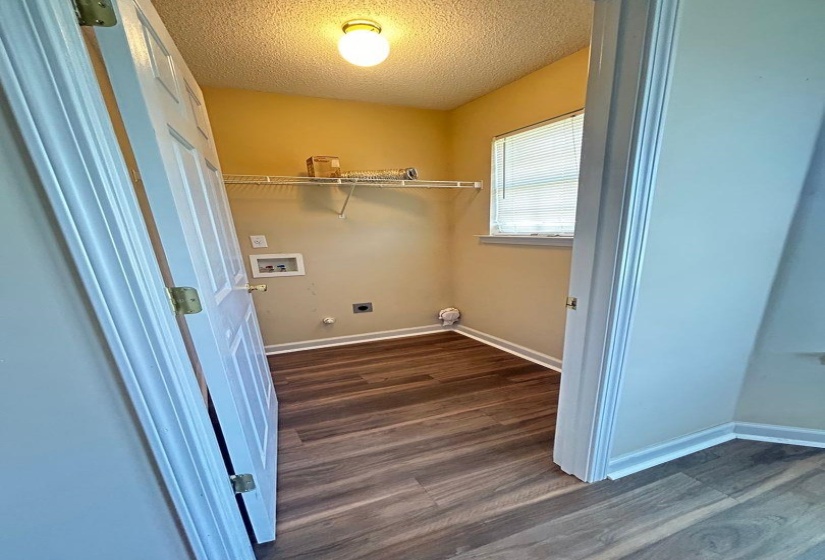 Laundry area with dark wood-type flooring, a textured ceiling, washer hookup, and hookup for an electric dryer