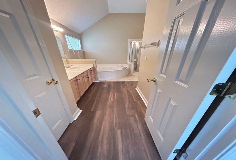 Bathroom featuring vanity, a bath, dark wood-style flooring, a shower stall, and high vaulted ceiling