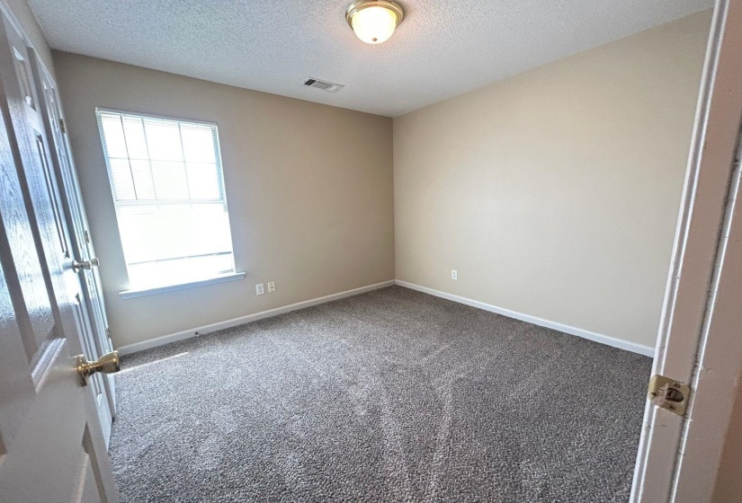 Carpeted spare room featuring baseboards and a textured ceiling