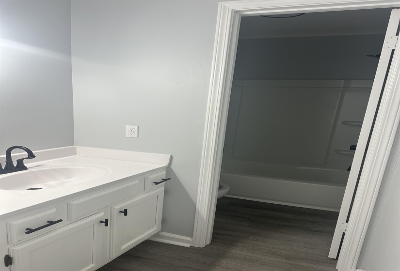 Full bathroom with vanity, shower / bathtub combination, and dark wood-style floors