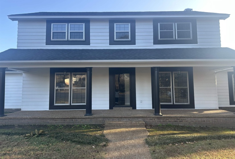 View of front of house with covered porch and a shingled roof