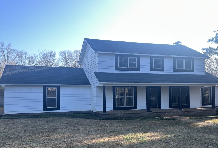 View of front of property with a porch, a shingled roof, and a chimney