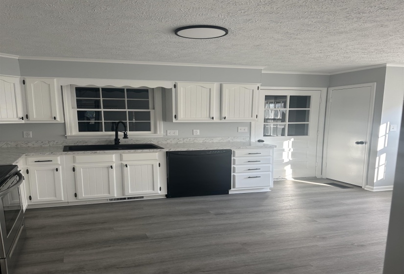 Kitchen featuring white cabinets, a textured ceiling, dishwasher, crown molding, and electric range oven