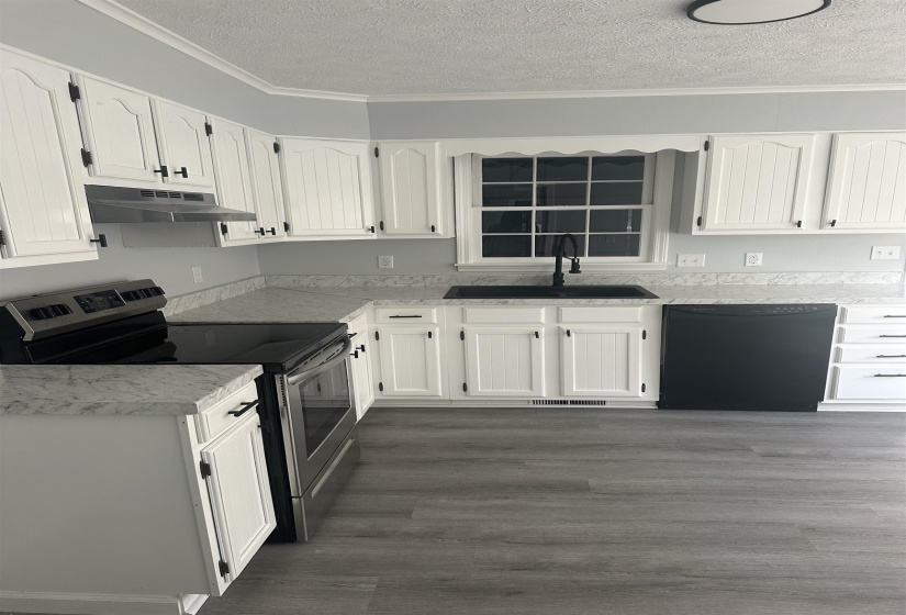 Kitchen featuring electric stove, white cabinetry, a textured ceiling, light countertops, and dishwasher