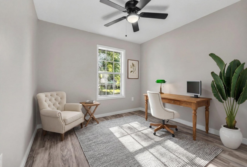 Office area with light wood-style floors and a ceiling fan
