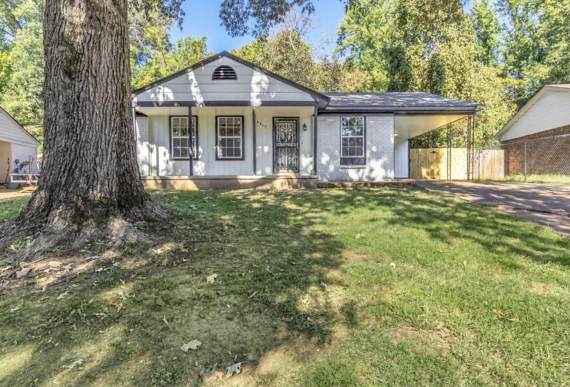 View of front of home featuring covered porch, brick siding, a carport, and driveway