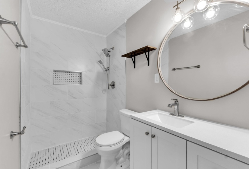 Bathroom with a shower stall, vanity, and a textured ceiling
