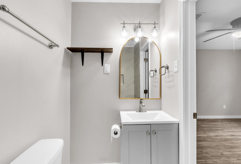 Half bath with vanity, ceiling fan, and wood finished floors
