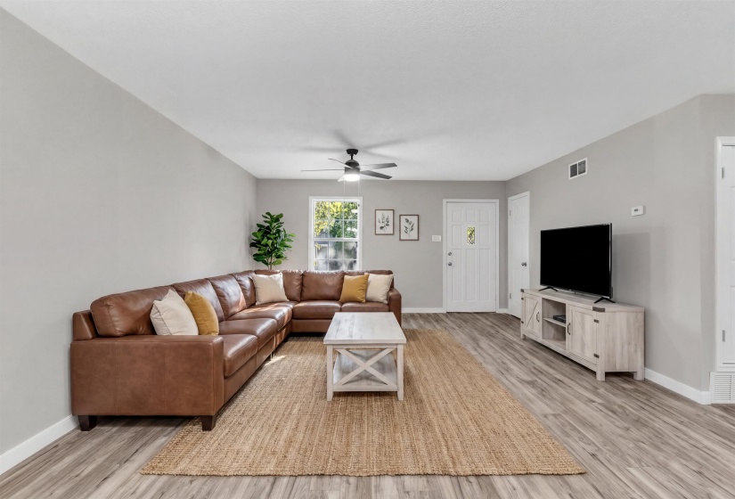 Living room with light wood-style floors and a ceiling fan